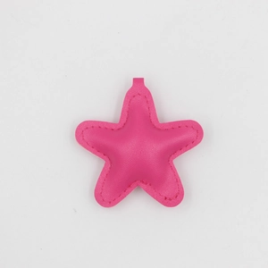 Vue détaillée du porte-clés étoile en cuir rose rouge avec texture grainée de qualité