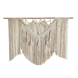 Handwoven macrame wall hanging with bohemian fringe and wooden beam in natural white cotton
