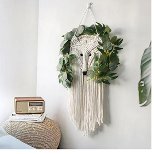 Detail of fox-shaped bohemian macrame wall hanging with handmade cotton tassels