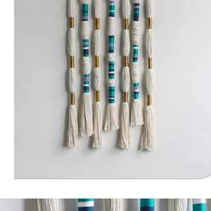 Detail of Nordic handmade woven wall hanging featuring colorful tassels and bohemian cotton cord