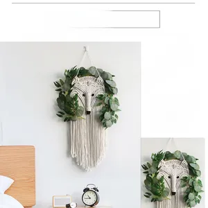 Detailed view of handmade cotton macrame fox wall hanging with fringe and green leaves