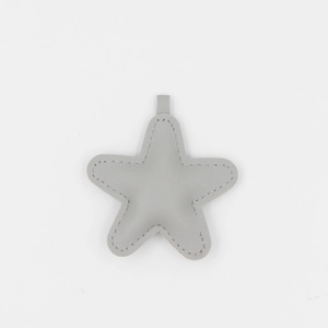 Détail d'un pendentif étoile en cuir PU gris avec finition texturée et coutures