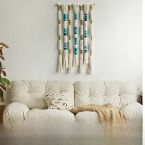 Detail of bohemian hand-woven tapestry with blue tassels on a natural wooden bar