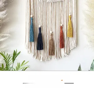 Detail of bohemian woven wall hanging featuring colorful tassels and wooden beads