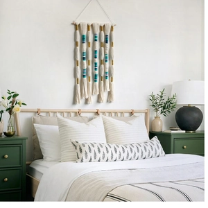 Detail of bohemian handmade woven wall hanging tapestry with gold and blue fringe accents