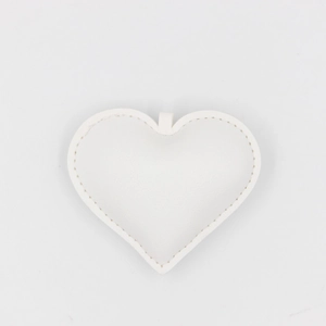 Detailed view of a white PU leather heart charm with decorative white stitching accents