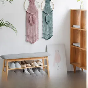 Detail of leaf-shaped hand-woven wall hangings with bohemian fringes and wooden rings