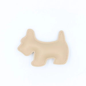 Close-up of beige leather Scottish Terrier keychain with premium lychee grain texture