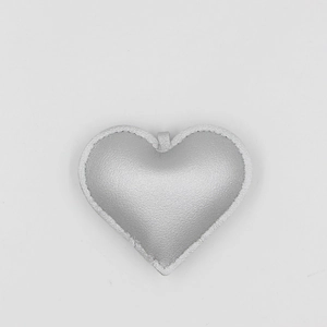 Close-up of heart-shaped silver PU leather keychain with white hand-stitched details