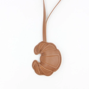 Cute brown PU leather croissant bag charm with hanging strap and fine stitching