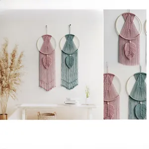 Close-up of bohemian hand-woven wall hanging with cotton cords and leaf-shaped pendants