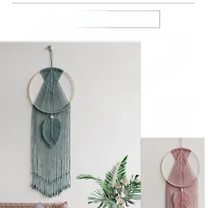 Detail of handcrafted bohemian macrame wall hanging with woven leaves and long tassels
