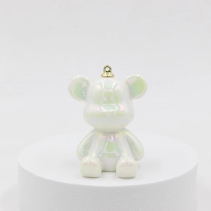 Detail of laser candy color resin bear keychain with white pearl finish and gold ring