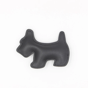 Detail of a black pebbled leather dog keychain featuring refined stitching and 3D design