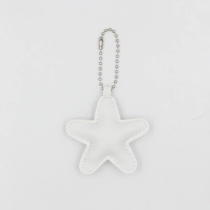 Detailed view of white star-shaped PU leather keychain with silver ball chain and stitching