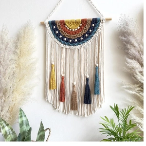 Detail of bohemian macrame wall hanging with colorful woven rainbow and tassels