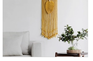 Detailed leaf-shaped macramé wall hanging in mustard yellow with elegant fringe