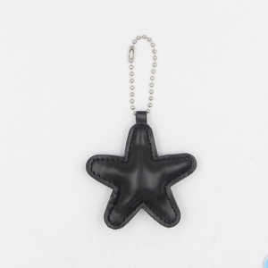 Close-up of a black PU leather star keychain with detailed stitching and silver bead chain