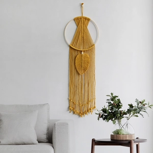 Handmade yellow bohemian macrame wall hanging with wooden ring and cotton leaf fringe