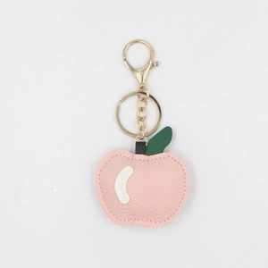 Détail du porte-clés pomme en cuir PU rose texturé avec fermoir doré brillant