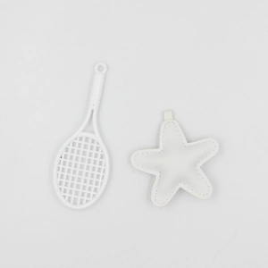 Close-up of white mini tennis racket and stitched star keychain pendant detail