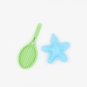 Green plastic badminton racket and blue star keychain pendant on white background
