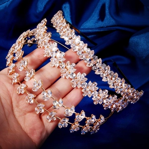 Détails de serre-têtes en zircon étincelant plaqués or sur un fond de satin bleu profond