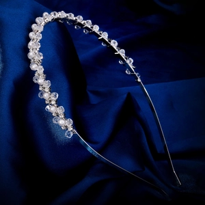 Eleganter handgefertigter Perlen-Haarreif mit Kristallperlen auf blauem Satinhintergrund