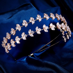 Détail d'un serre-tête de mariée doré avec feuilles de zircon sur fond de soie bleue