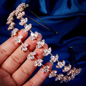 Détail d'un serre-tête doré avec des feuilles en zircone cubique sur satin bleu