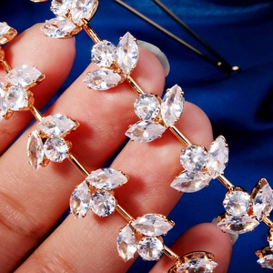 Vue macro d'un diadème doré en forme de feuilles avec strass sur satin bleu marine