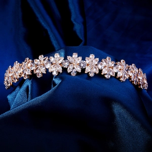 Détail d'un serre-tête doré en zircon avec motifs floraux marquise sur satin bleu