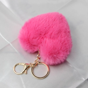 Detail of soft heart-shaped plush keychain in rose red with golden lobster clasp and chain