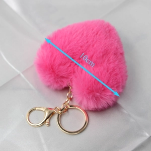 Detail showing a 10cm pink plush heart keychain with gold metal lobster clasp