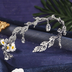 Close-up of silver leaf tiara with sparkling crystals and teardrop pendants on blue silk