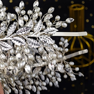Close-up of silver metal leaf headband with woven pearls and crystal rhinestones