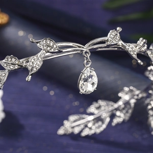 Macro shot of silver bridal leaf tiara featuring crystal drop pendant and rhinestones
