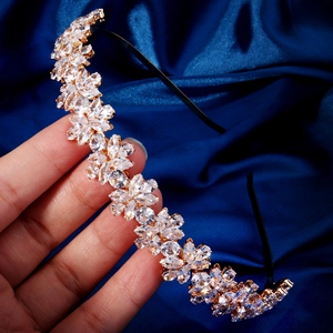 Détail d'un serre-tête doré avec cristaux marquise sur fond de soie bleu foncé élégant