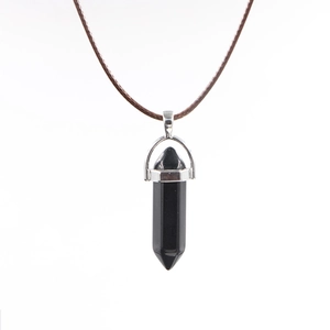 Detail of a polished black hexagonal crystal stone pendant with silver metal bail clasp