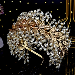 Detailed close-up of luxury bridal headband with golden leaves, pearls and crystals