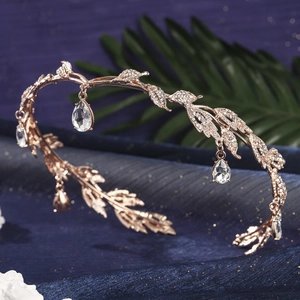 Macro detail of rose gold crystal crown with leaf motifs and water drop pendants