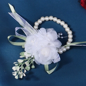 Elegant wedding wrist corsage with white chiffon roses, green ribbons and pearl bracelet