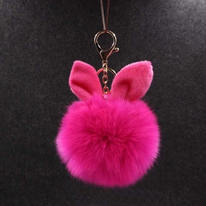 Détail du porte-clés pompon rouge rose avec oreilles de lapin et fermoir doré chic