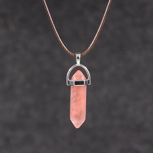 Detail of pink crystal hexagonal column pendant with silver clasp on brown woven cord