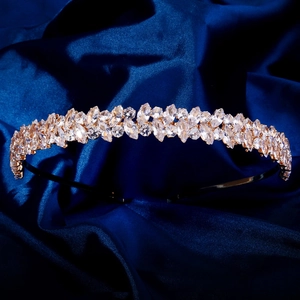 Détail d'un serre-tête en or avec cristaux marquise sur fond de soie bleu foncé luxueux