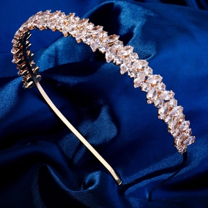 Détail de pierres de zircon marquise sur un serre-tête doré sur soie bleue