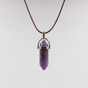Macro detail of hexagonal purple amethyst crystal pendant with silver clasp and cord