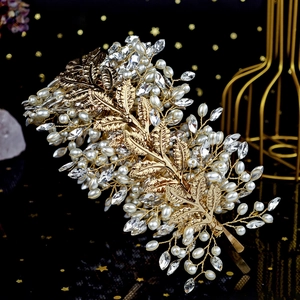 Close-up of golden metal leaves and pearls on an ornate handcrafted floral headband
