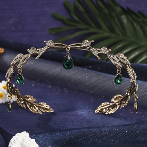 Detail of vintage crown featuring bronze leaf patterns and green teardrop gemstone pendants