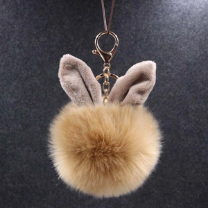 Détail d'un porte-clés pompon en peluche de 10cm avec oreilles de lapin et fermoir doré